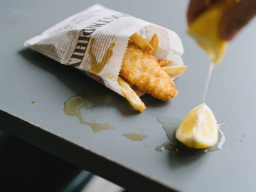挤柠檬汁的炸鱼薯条