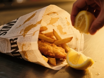 挤柠檬汁的炸鱼薯条