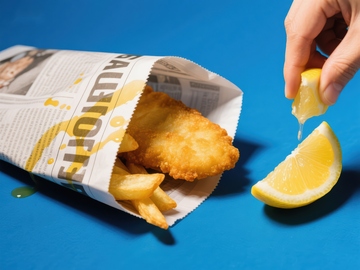 挤柠檬汁的炸鱼薯条