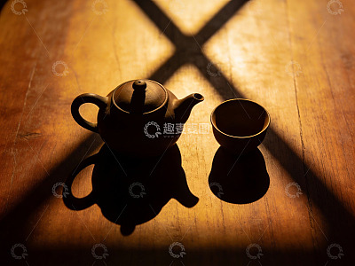 暖光下的紫砂壶与茶杯