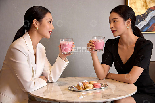 两位女士咖啡厅举杯交谈