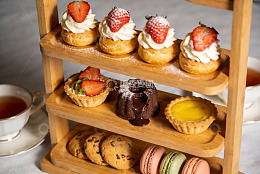 三层木质甜品架摆满精致糕点
