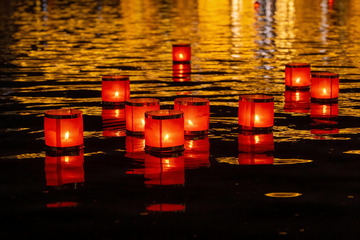 夜色中水面漂浮的红色烛光
