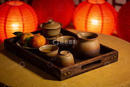 暖光灯笼下的茶具与柑橘