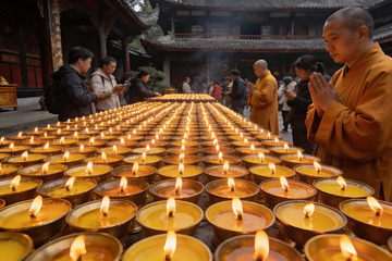 寺庙僧侣与信徒点燃蜡烛祈福