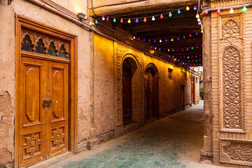 古巷彩灯映衬下的木质门扉