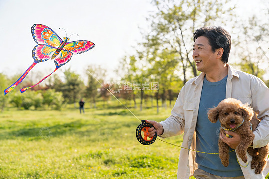 男子公园放风筝抱狗