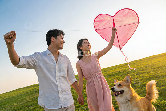 情侣放飞爱心风筝与宠物狗