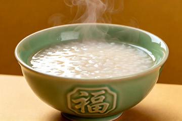热气腾腾的米粥盛在青瓷碗中